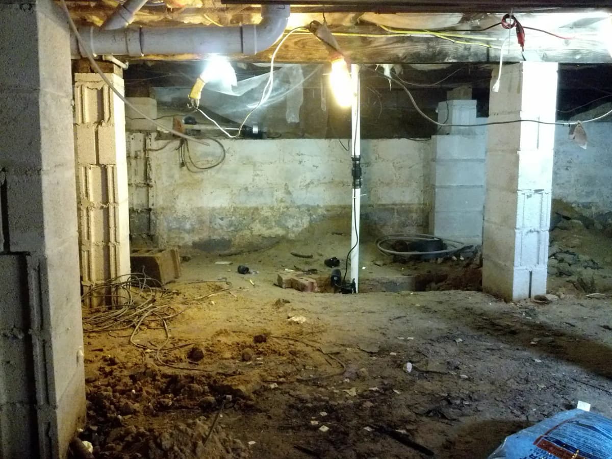 Crawl space before encapsulation showing moisture, mold, and deteriorated conditions