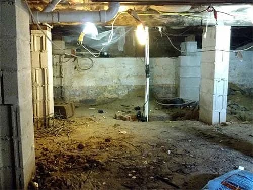 Basement before sump pump installation showing water damage and flooding vulnerability